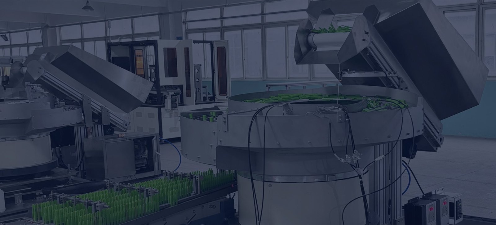 Automated component feeding line with vibratory feeders and inline tracks in a production environment